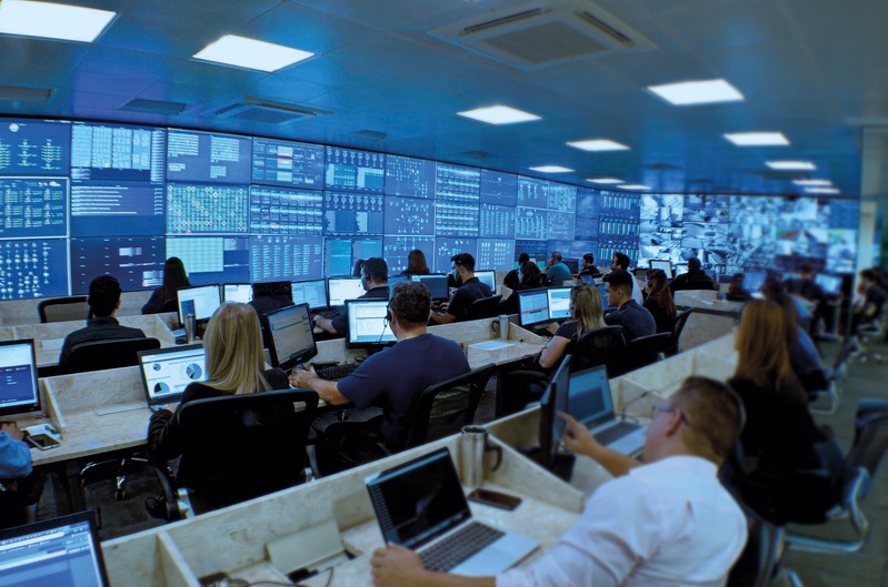 Central de monitoramento com equipe acompanhando painéis